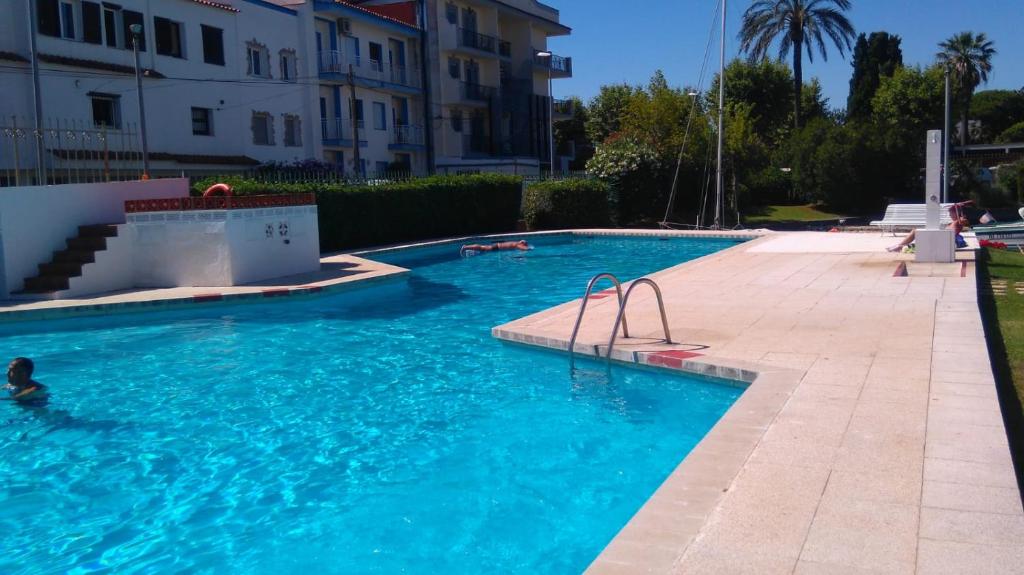 uma piscina com uma pessoa na água em PORT SOTAVENT 2C - Apartamento en la Marina de Empuriabrava - piscina comunitaria, - parking - vistas al canal - cerca centro y playa em Empuriabrava