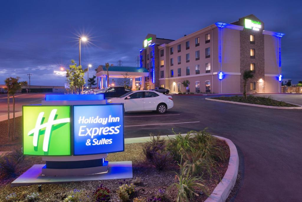 een bord op een parkeerplaats voor een hotel bij Holiday Inn Express & Suites Bakersfield Airport, an IHG Hotel in Bakersfield