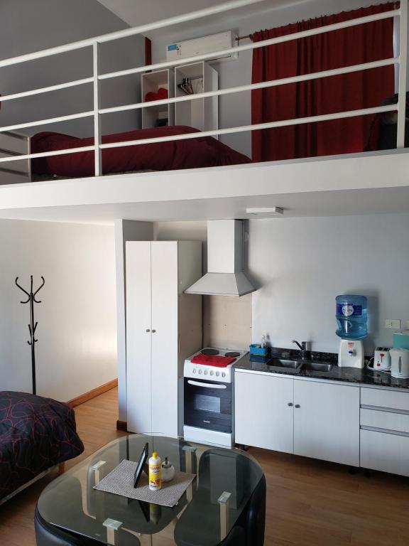 sala de estar con cocina y cama elevada en Lugones, en Ezeiza