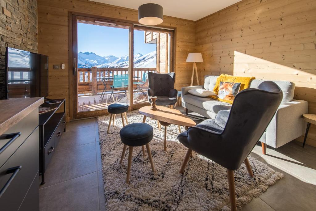 uma sala de estar com um sofá e uma mesa em ODYSSEE B201 - Magnifique Duplex sur les pistes em La Toussuire