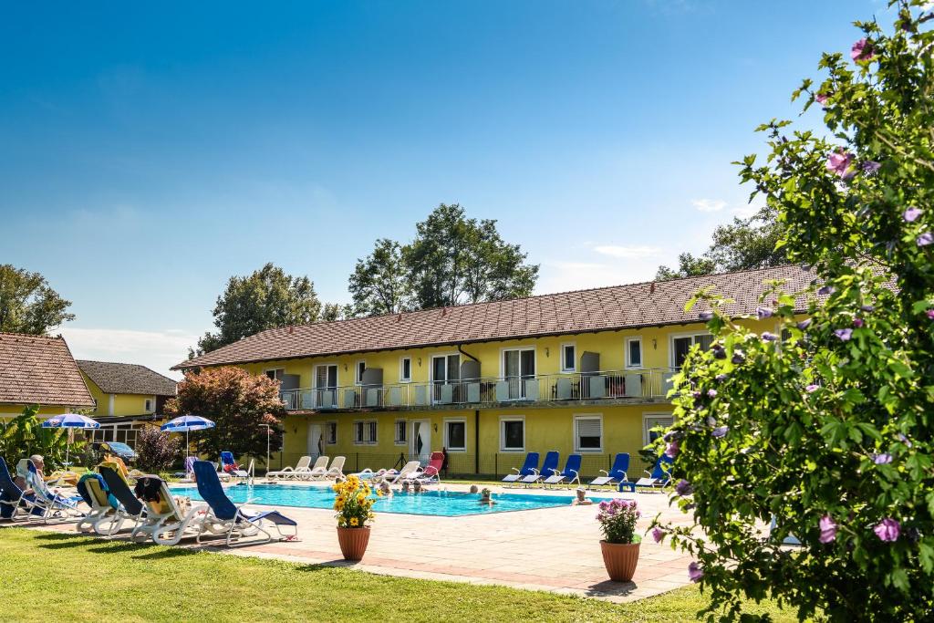 巴特拉德克斯堡的住宿－Gasthof Zum Lindenhof，一座设有游泳池的酒店,人们坐在椅子上
