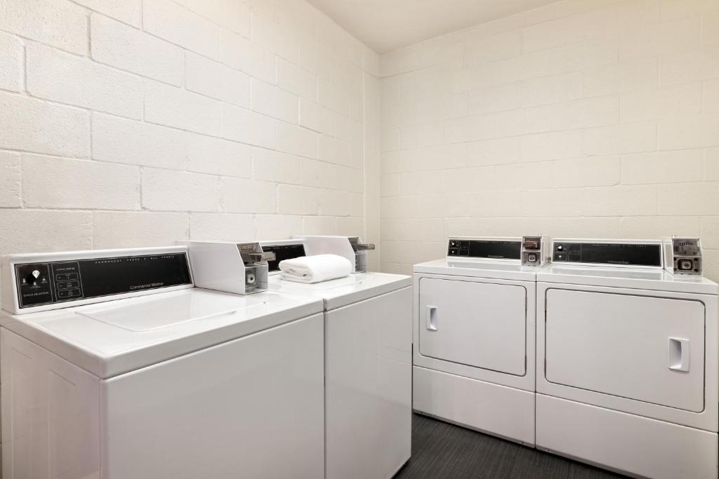 a white laundry room with two washes and a sink at Holiday Inn Houston Intercontinental Airport by IHG in Houston