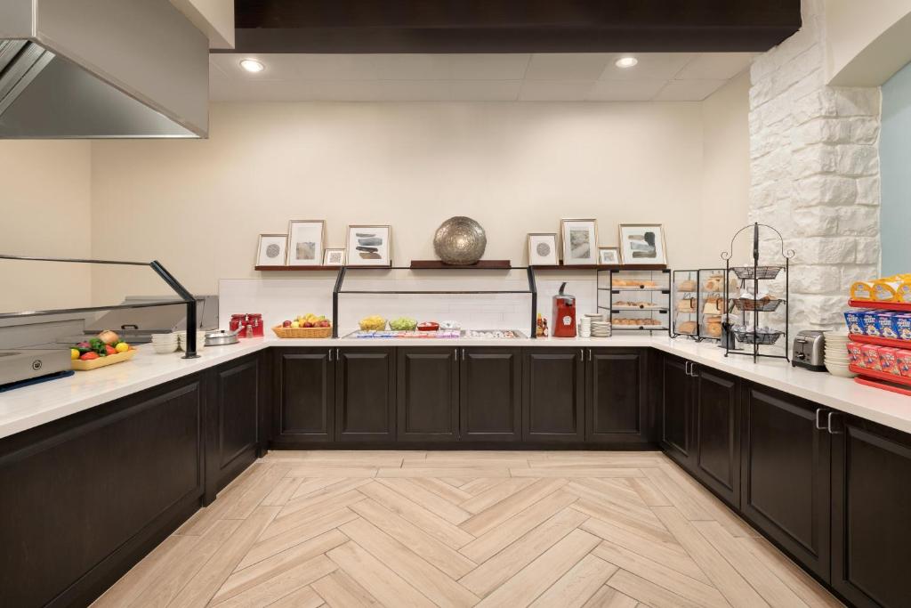 a kitchen with black cabinets and white counter tops at Holiday Inn Houston Intercontinental Airport by IHG in Houston