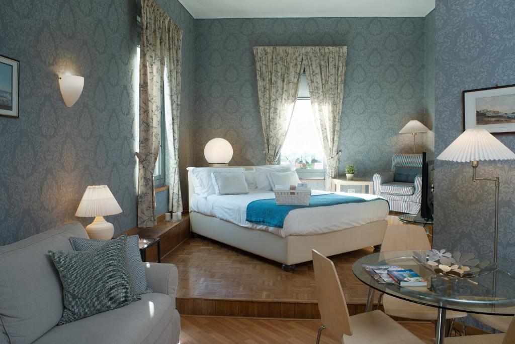 a bedroom with a bed and a table and a couch at Residenza Echia in Naples