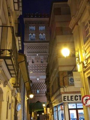 a tall building in the middle of a street at night at san leon in Teruel
