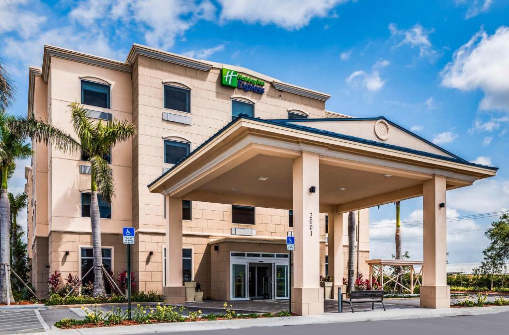 a hotel with a sign on top of a building at Holiday Inn Express & Suites Boynton Beach East, an IHG Hotel in Boynton Beach