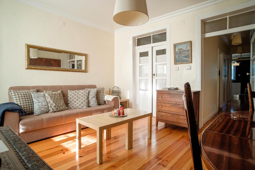 ein Wohnzimmer mit einem Sofa und einem Tisch in der Unterkunft Pasteleiro House in Lissabon