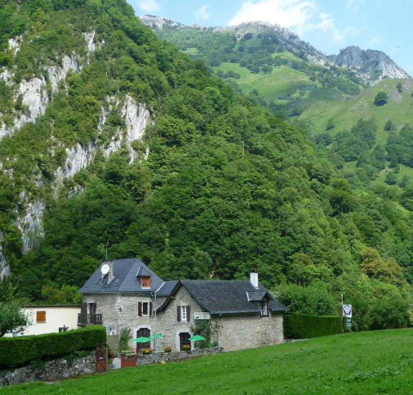 a house in a field with mountains in the background at Maison de vacance La Cavalière in Accous