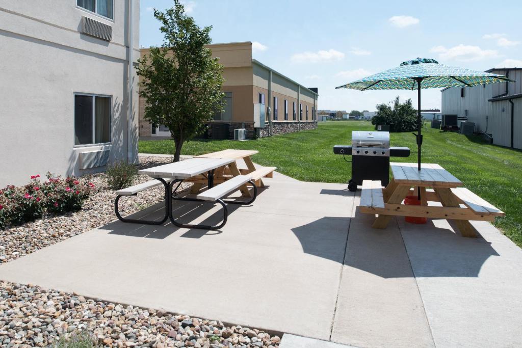 einen Picknicktisch und einen Grill mit Sonnenschirm in der Unterkunft Holiday Inn Express Hotel & Suites Burlington, an IHG Hotel in Burlington