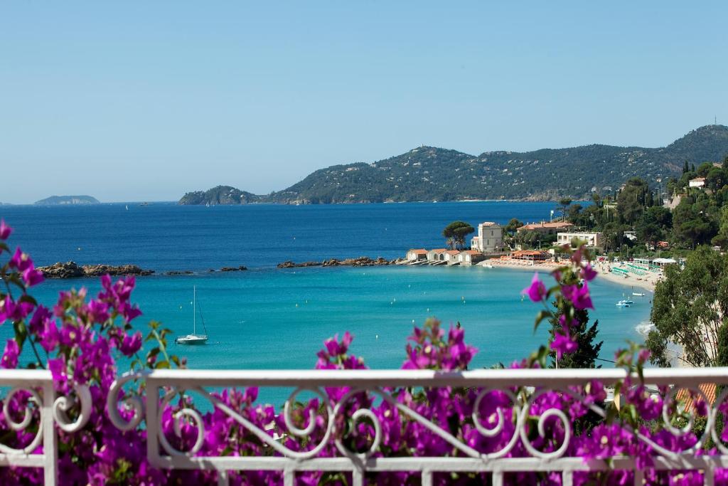 vista su una spiaggia con fiori viola di Hotel Belle Vue a Le Lavandou