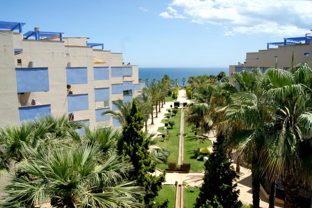 vistas a un edificio con palmeras y al océano en CALAS AGUAMARINA - Campoamor - Primera Linea, en Campoamor