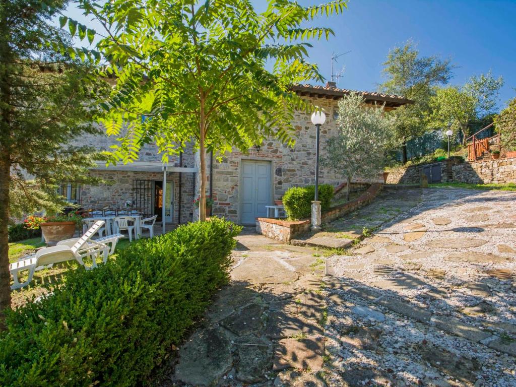 a stone house with a patio and a tree at Holiday Home Casale Labbia by Interhome in Barberino di Mugello