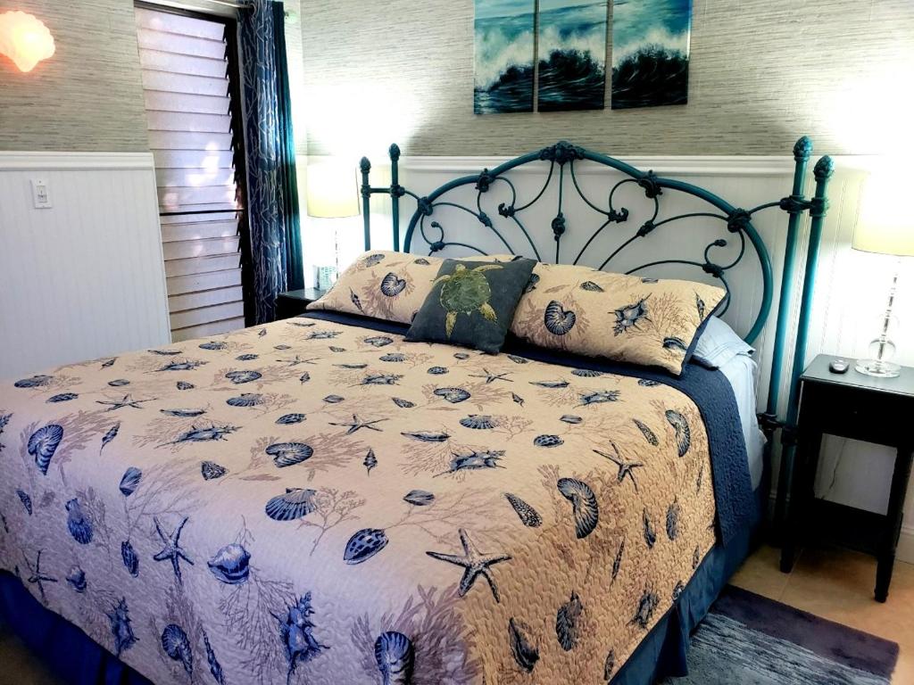 1 dormitorio con 1 cama con colcha azul estampada en Maui Tranquility, en Kihei