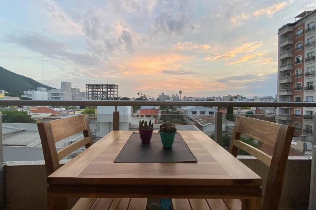 - une table en bois sur un balcon avec vue sur la ville dans l'établissement Luxury Appart, à Salta