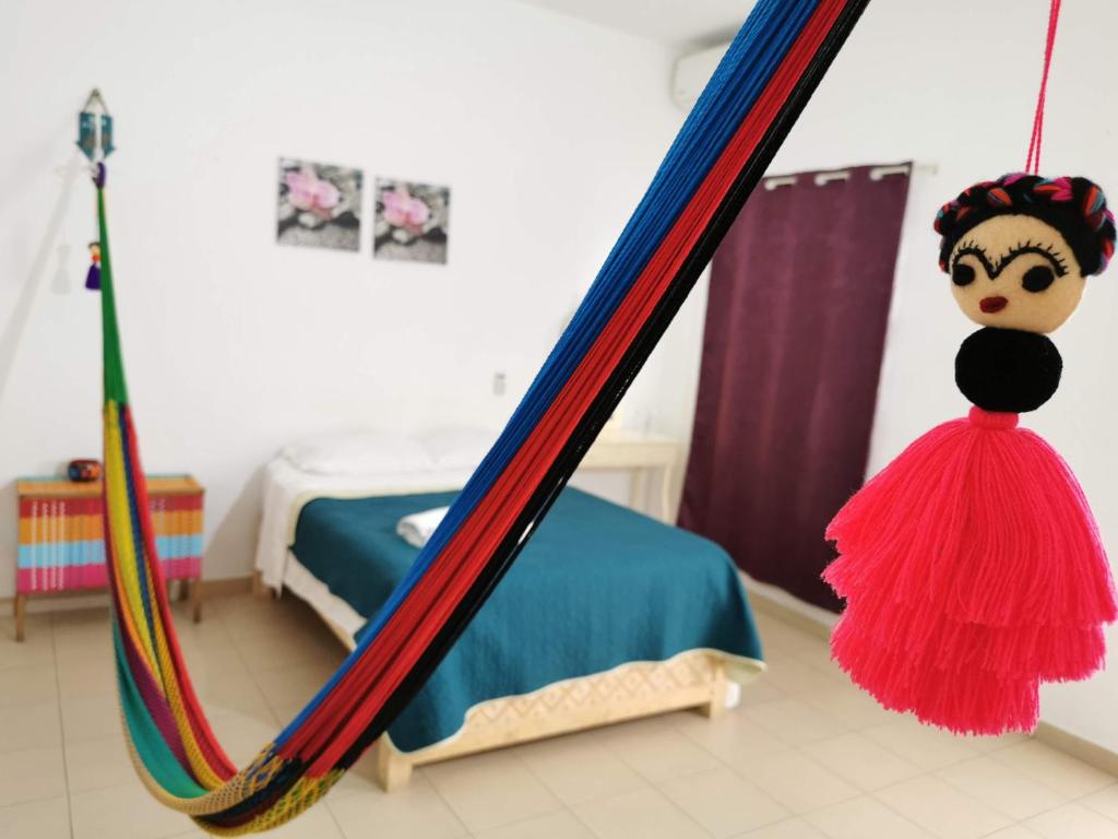 a doll is standing in front of a bed at Terraza Tuxtla in Tuxtla Gutiérrez