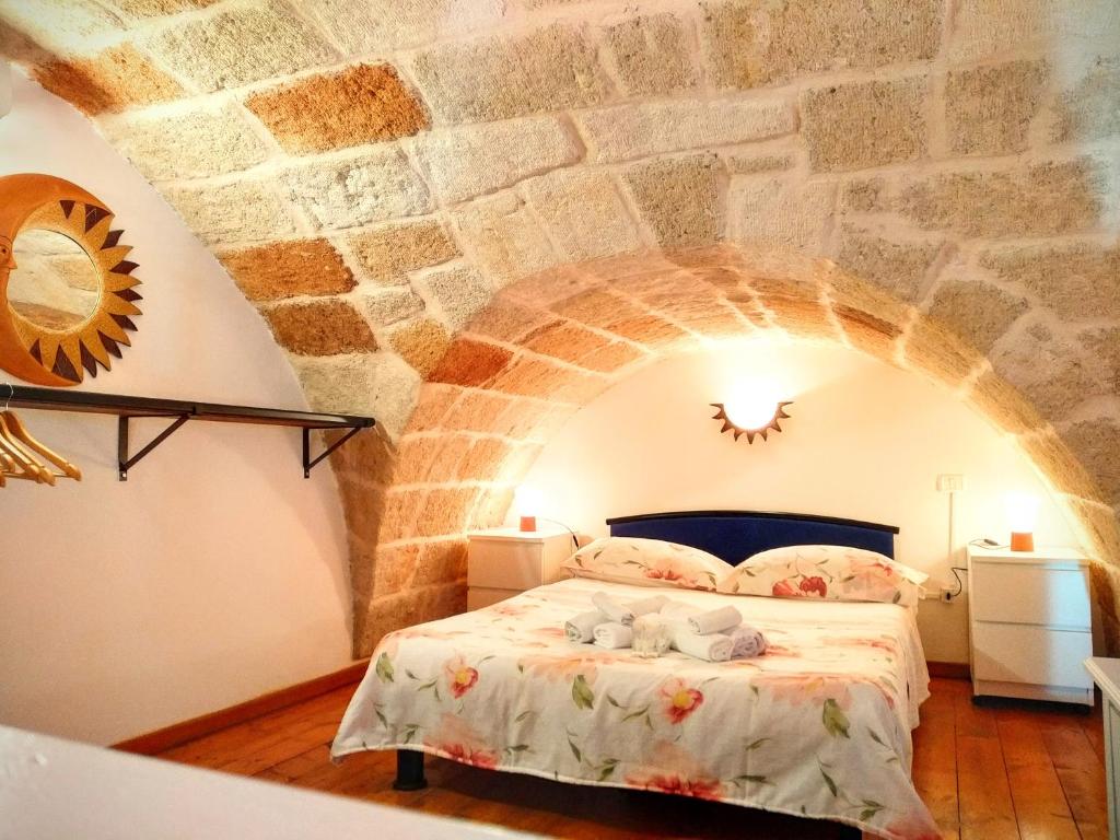 - une chambre avec un lit dans un mur en pierre dans l'établissement Dimora la Sirenetta, à Polignano a Mare