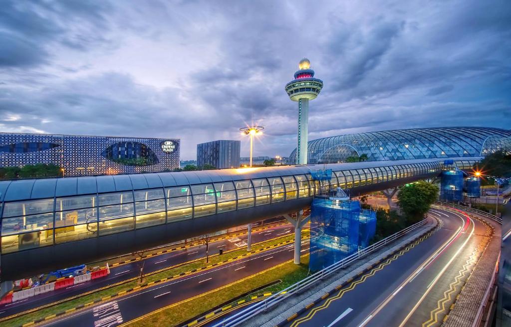 een uitzicht op een stad met een toren en een snelweg bij Crowne Plaza Changi Airport, an IHG Hotel in Singapore