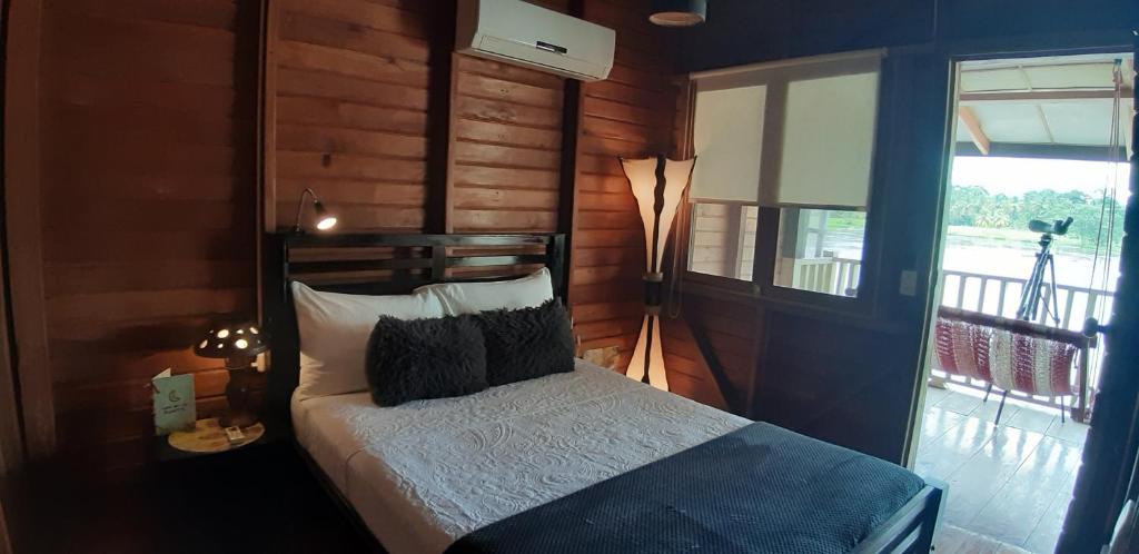 - une chambre avec un lit dans une pièce dotée d'une fenêtre dans l'établissement Ecolodge Luna del Rio, à El Castillo de La Concepción