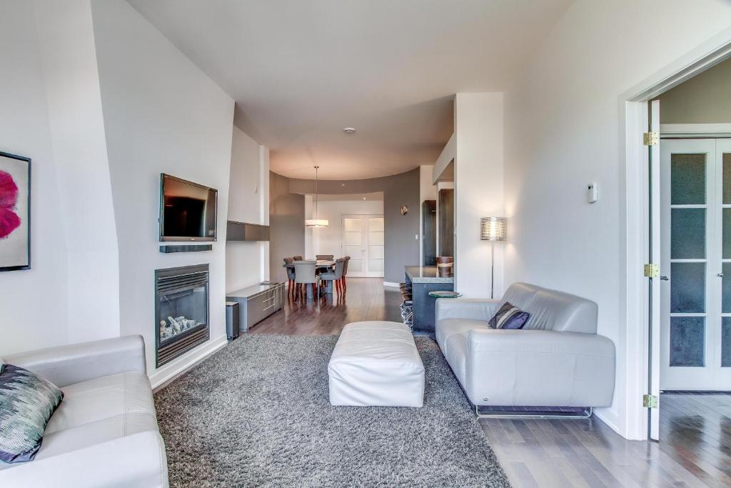 a living room with white furniture and a table at The Palace Condo by BnbCopilote in Quebec City