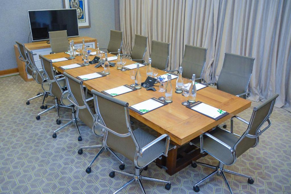 a large conference room with a long wooden table and chairs at Holiday Inn Mauritius Mon Trésor, an IHG Hotel in Blue Bay