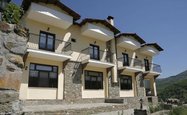 un gran edificio con balcones en un lateral en Guesthouse Mirihos, en Vlásti