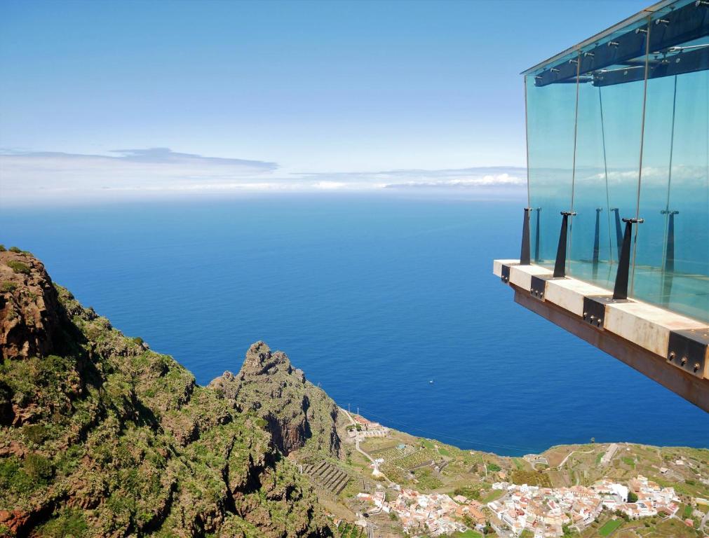 a bridge over the ocean next to a mountain at Casa Rural Maria in Hermigua