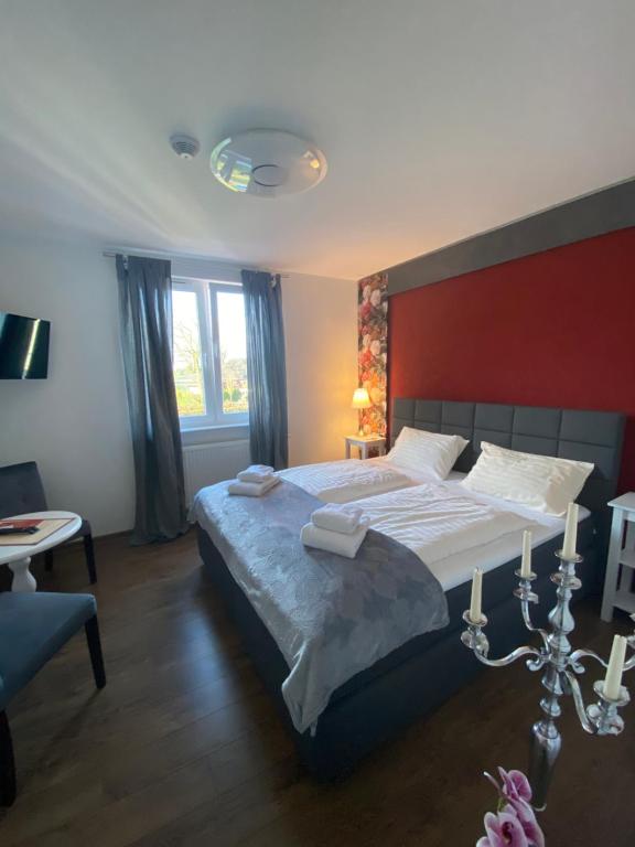 sypialnia z dużym łóżkiem z czerwoną ścianą w obiekcie Der Tanzhase w mieście Hasenmoor