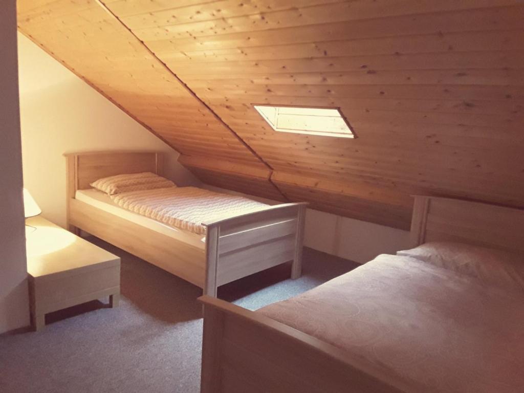 a attic room with two beds and a skylight at Monteurwohnung - Business Apartment in Wertheim