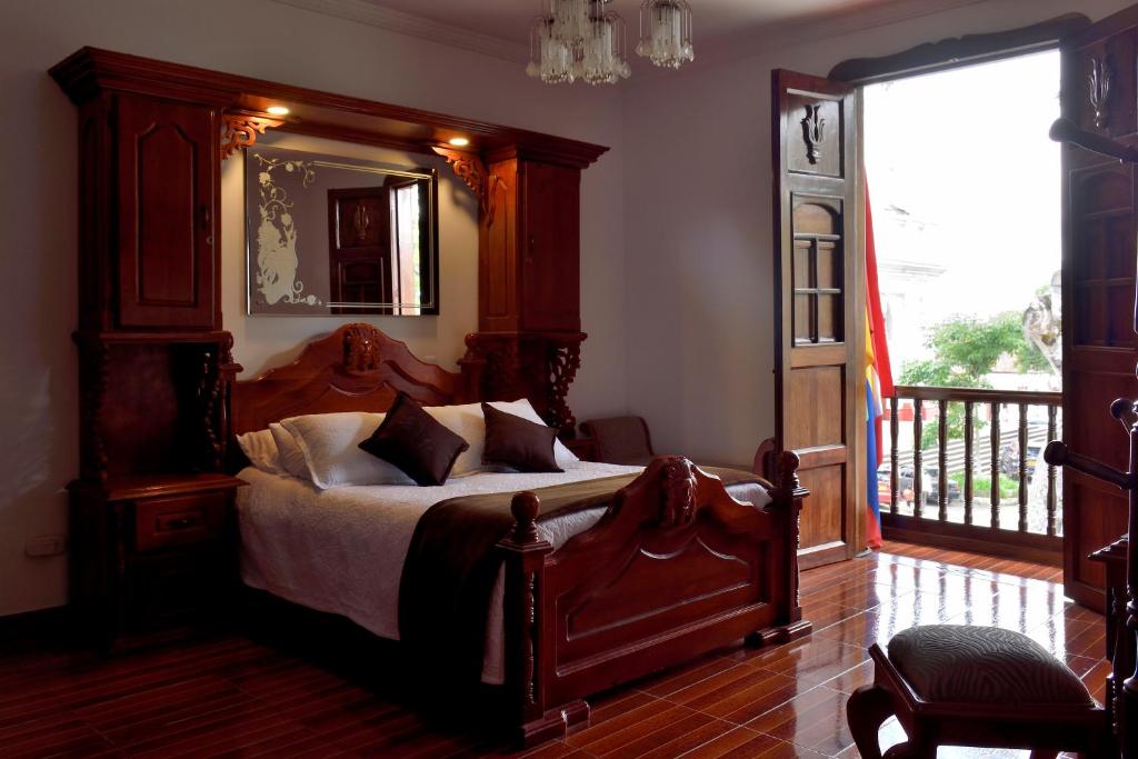 a bedroom with a bed with a large wooden headboard at Las Marías Family Home in Salamina