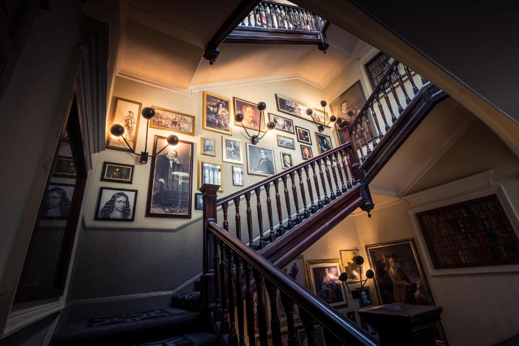 a hallway with a staircase with pictures on the wall at Hotel Indigo - Edinburgh - Princes Street by IHG in Edinburgh