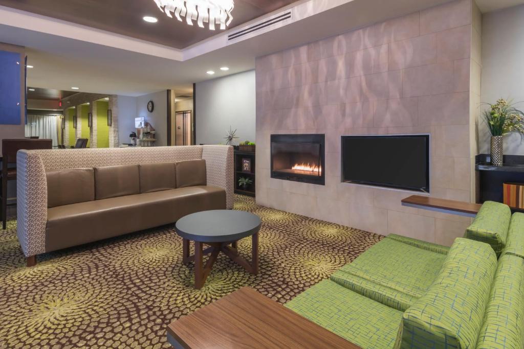 Una sala de estar con un sofá y una chimenea. en Holiday Inn Express Hays by IHG, en Hays