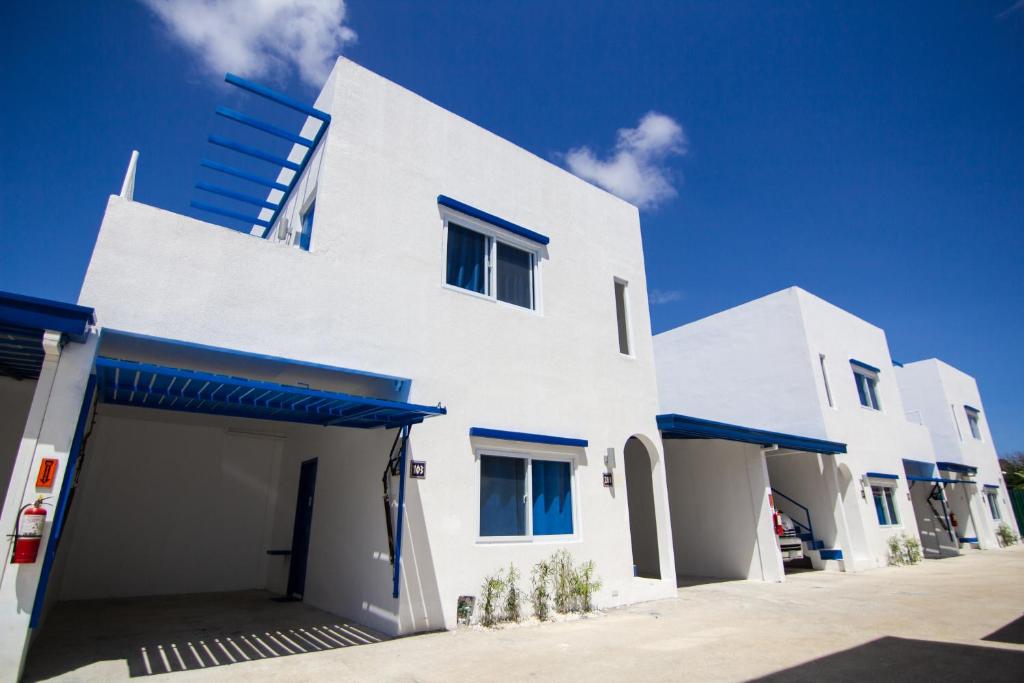 - un bâtiment blanc avec des fenêtres bleues et un ciel bleu dans l'établissement Skytel Palawan, à Puerto Princesa