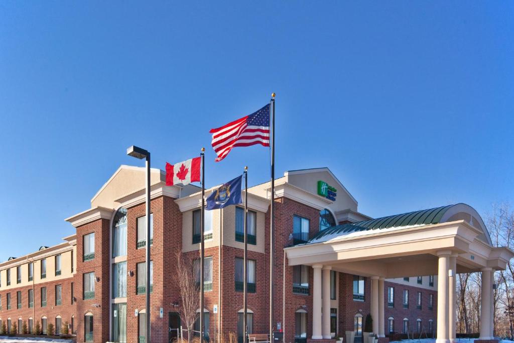 a building with three flags in front of it at Holiday Inn Express Hotel & Suites - Novi, an IHG Hotel in Novi