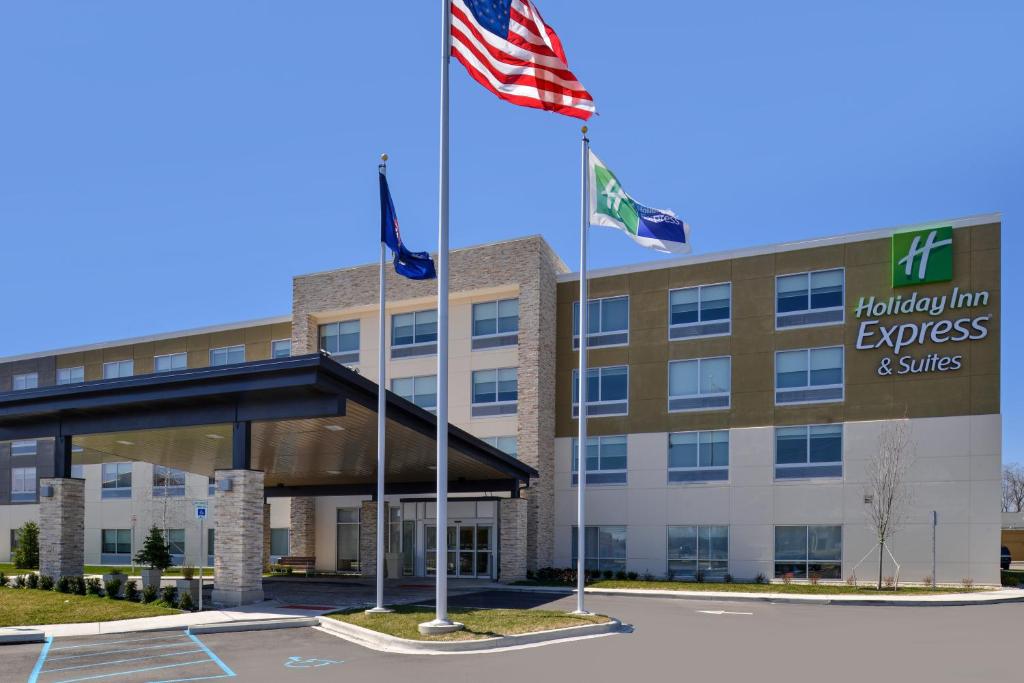 un immeuble de bureaux avec deux drapeaux devant lui dans l'établissement Holiday Inn Express & Suites Farmington Hills - Detroit, an IHG Hotel, à Farmington Hills