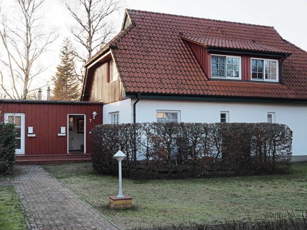 a white and red house with a red fence at DHH 7 Haus am Wiesengrund in Prerow