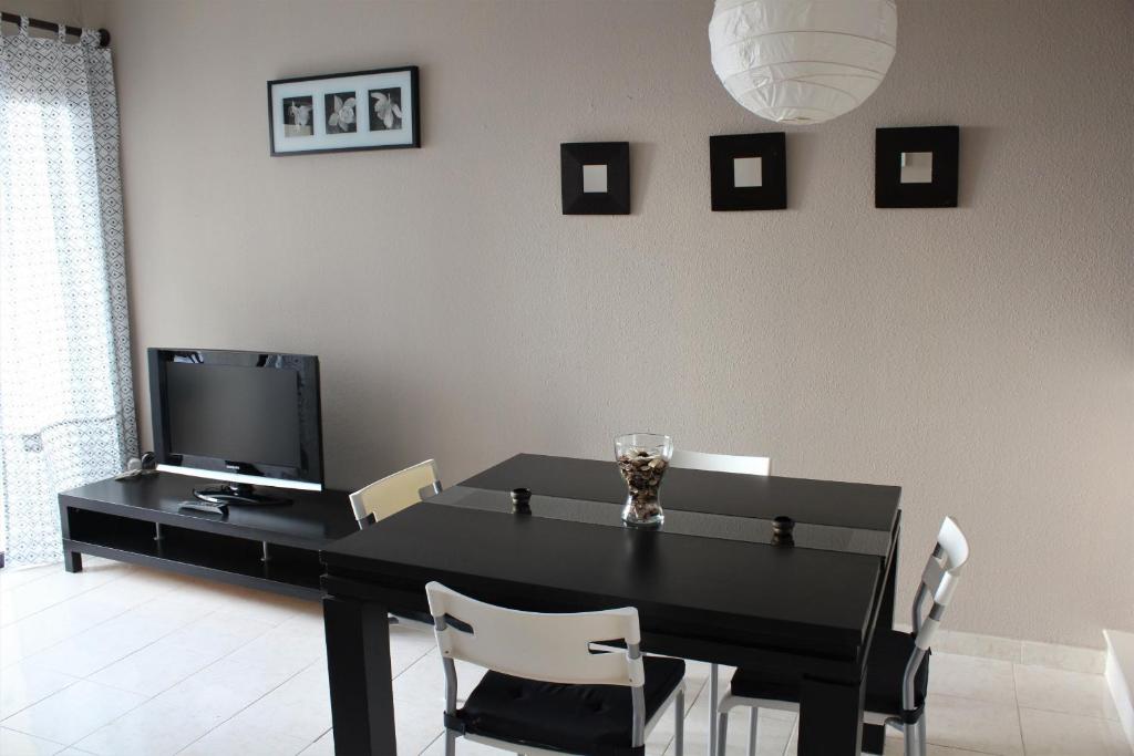 a dining room with a black table and chairs at Magnífico apartamento Playa Paraíso in Callao Salvaje