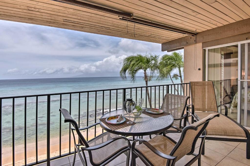 una mesa y sillas en un balcón con vistas al océano en Beachfront Lahaina Condo - Featured on HGTV!, en Kahana