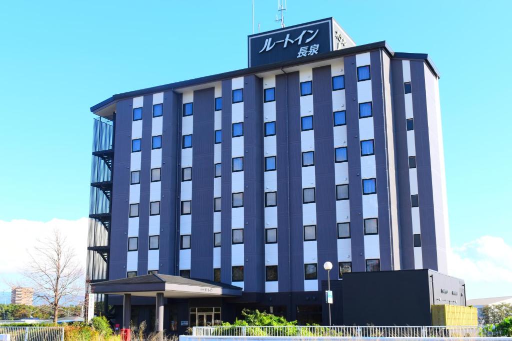 un edificio de hotel con un cartel encima en Hotel Route-Inn Nagaizumi Numazu Inter 1, en Nagaizumi