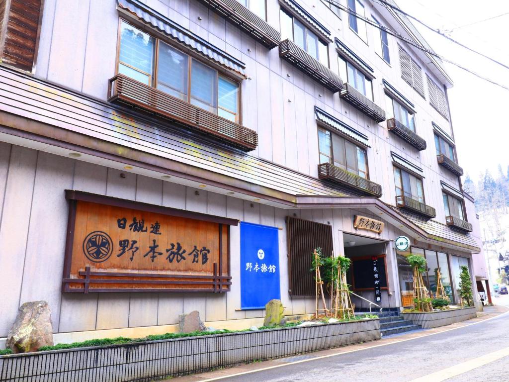 a building with a sign on the side of it at Nomoto Ryokan Matsunoyama Onsen in Tokamachi