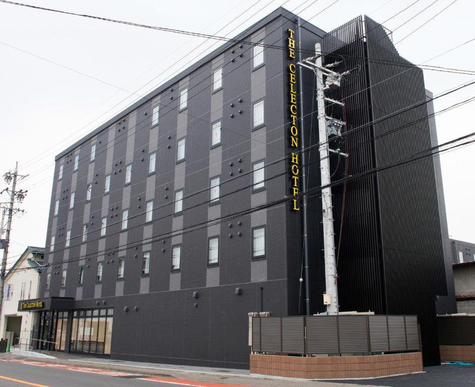 un edificio negro con un cartel en el costado en The Celecton Matsumoto en Matsumoto