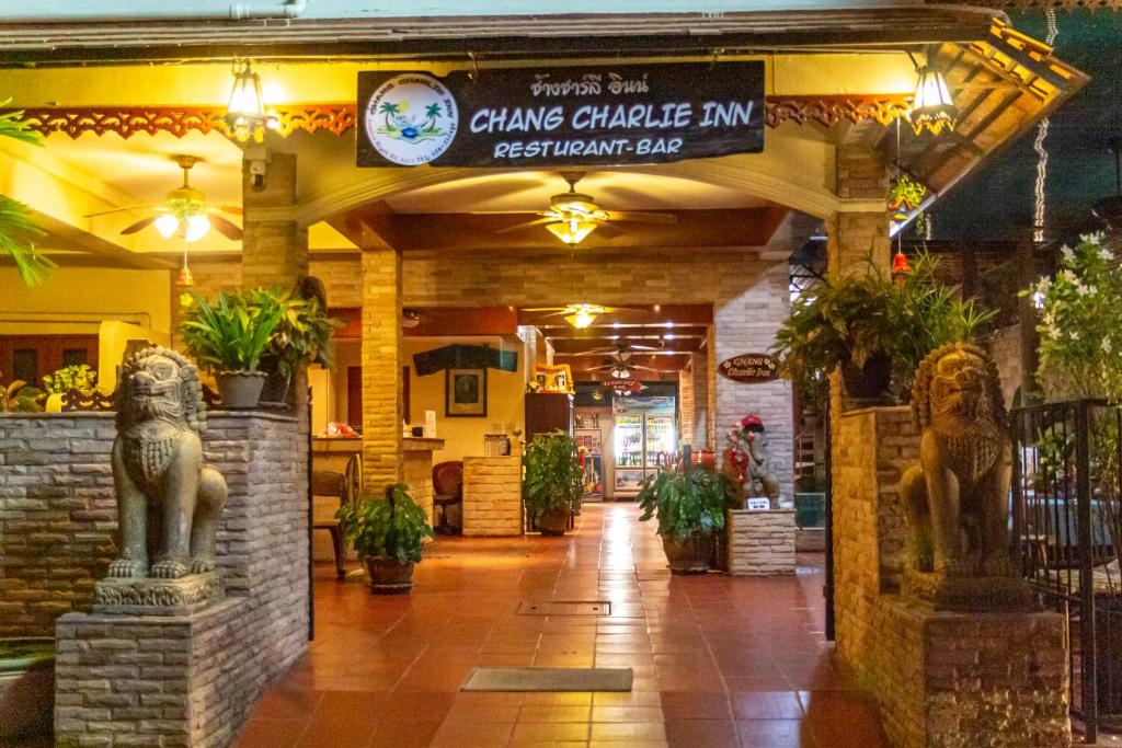 um restaurante com uma placa que lê chavez caritatiable inn bar restaurante em Chang Charlie Inn, Boutique em Praia de Jomtien