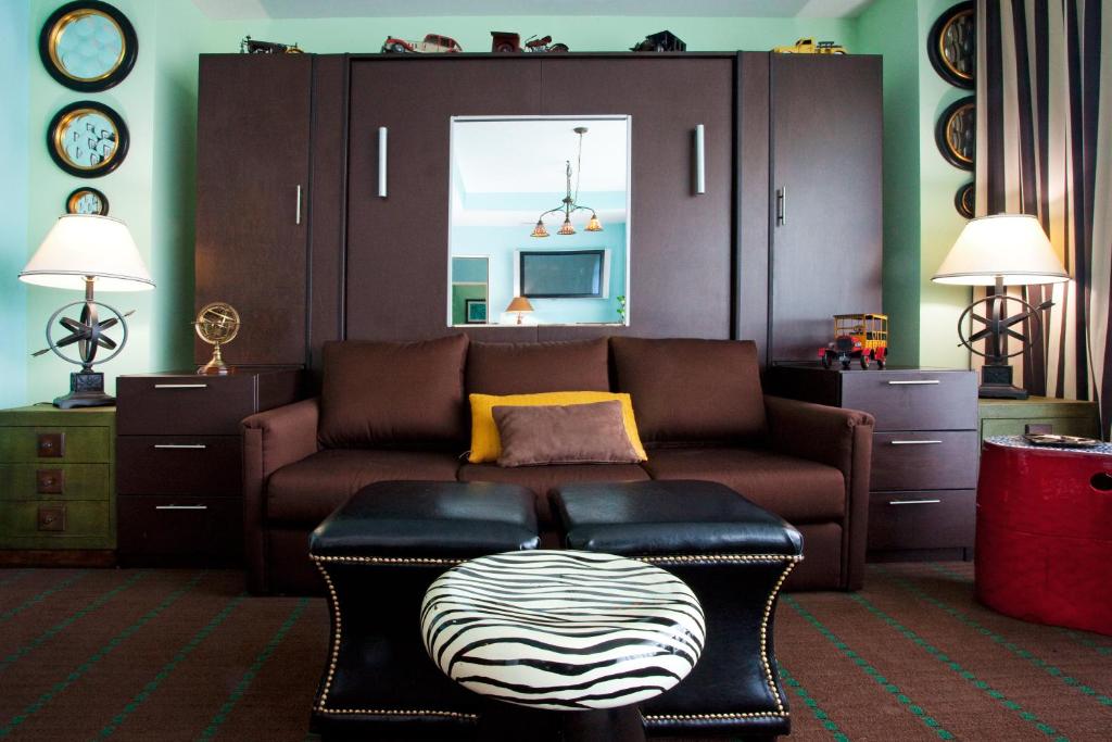 a living room with a couch and a stool at Holiday Inn Hotel & Suites Ocala Conference Center by IHG in Ocala