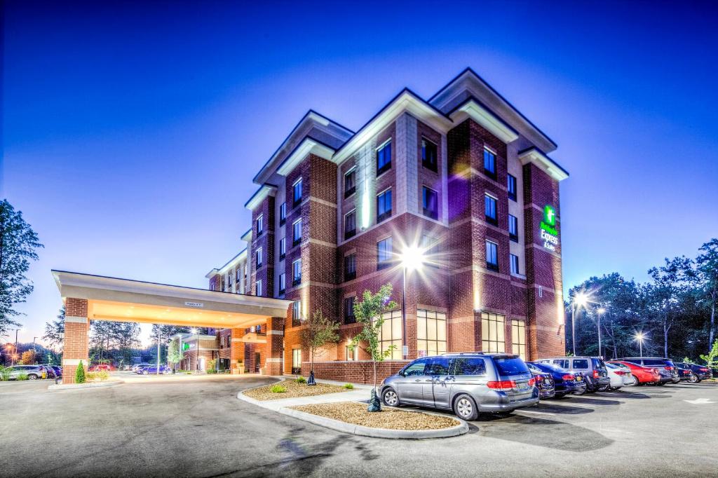 un edificio con coches estacionados en un estacionamiento en Holiday Inn Express & Suites Cleveland/Westlake, an IHG Hotel en Westlake