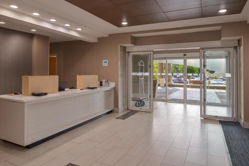 an office lobby with a reception desk and sliding glass doors at Holiday Inn Express & Suites Chattanooga - East Ridge by IHG in Chattanooga