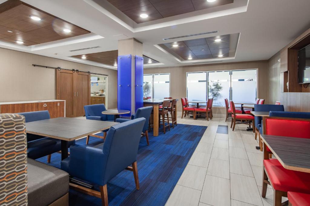 a dining room with tables and chairs and windows at Holiday Inn Express & Suites Chattanooga - East Ridge by IHG in Chattanooga