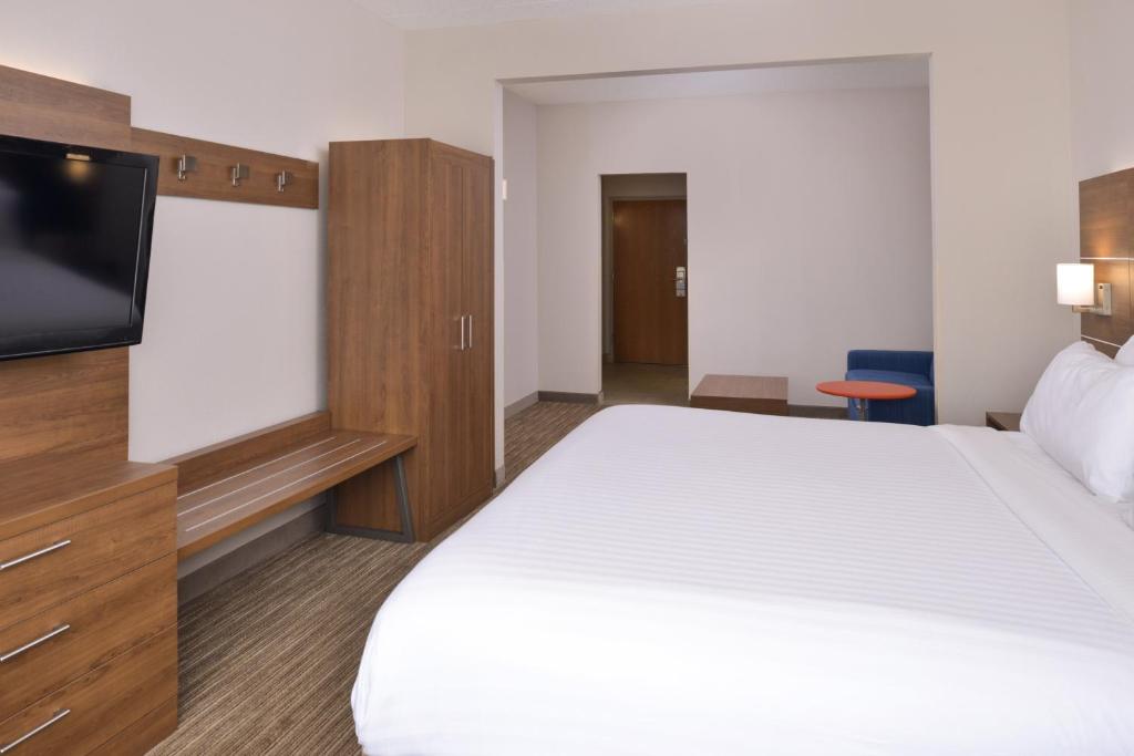 a hotel room with a bed and a flat screen tv at Holiday Inn Express & Suites Chattanooga - East Ridge by IHG in Chattanooga