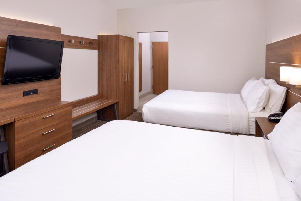 a hotel room with two beds and a flat screen tv at Holiday Inn Express & Suites Chattanooga - East Ridge by IHG in Chattanooga