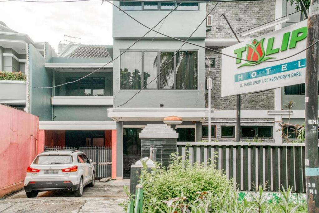 a car parked in front of a building at RedDoorz near Plaza Senayan in Jakarta