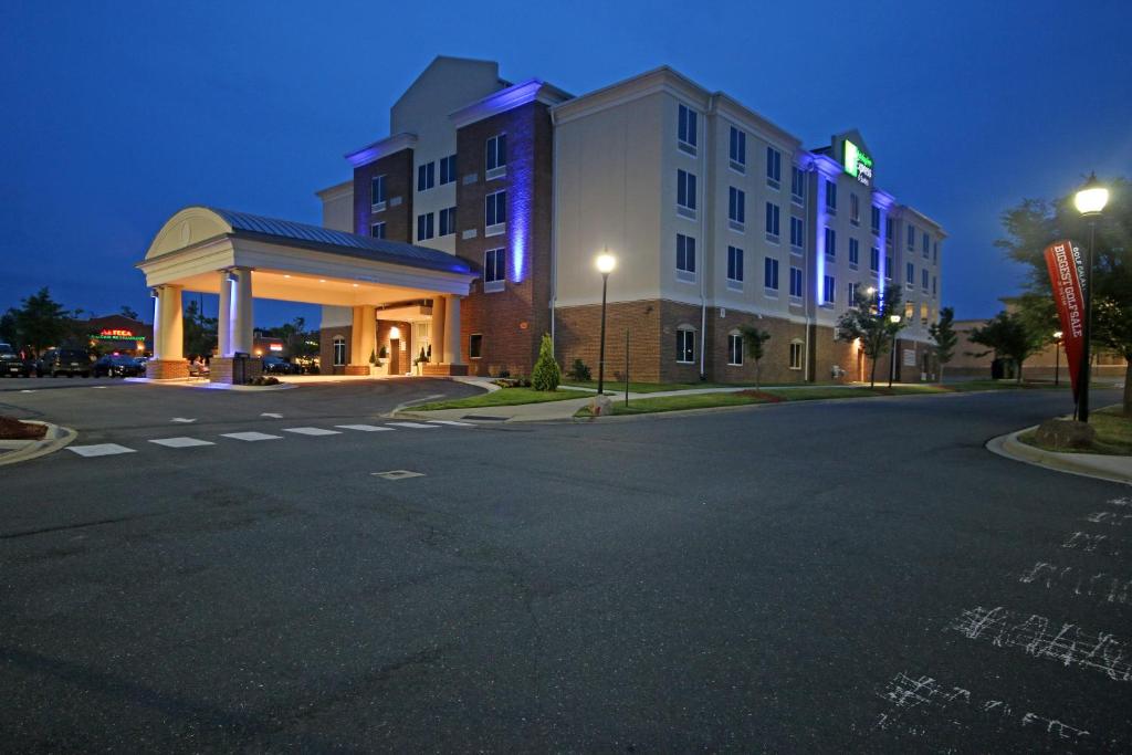 an empty street in front of a hotel at night at Holiday Inn Express & Suites Charlotte North, an IHG Hotel in Charlotte