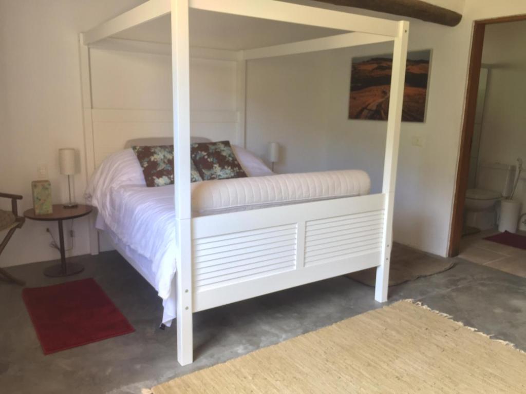a bedroom with a white bed with a canopy at Casa Cleo - Somente carro 4x4 ou fazemos translado sem custo in São Francisco Xavier